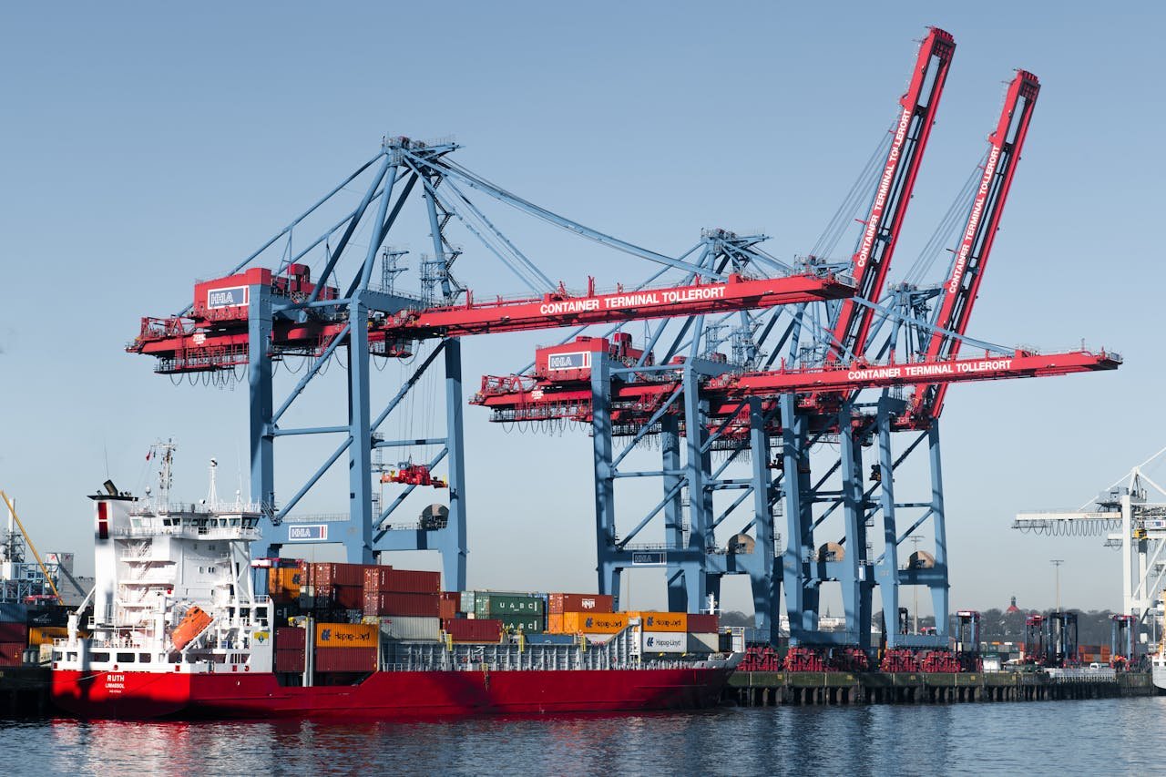 View of large container cranes and cargo ships at Hamburg port.